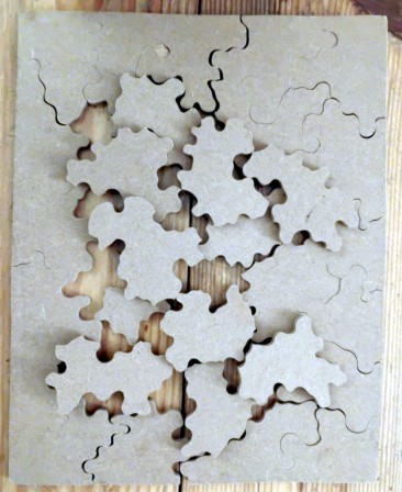 Un puzzle: les pièces sont de dos, le bord est reconstitué, le reste des pièces est disposé au milieu sans ordre particulier.